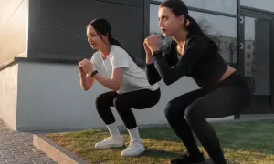 Dos mujeres hacen sentadillas, un ejercicio común en un entrenamiento AMRAP que es.