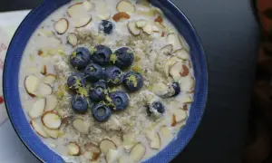 Un tazón de avena con arándanos y almendras. La inulina para que sirve, como fibra prebiótica, mejora la digestión y la salud intestinal.