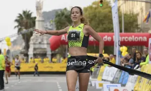 Meritxell Soler cruza la meta de una carrera en Barcelona, con el dorsal 51 y una expresión de esfuerzo.