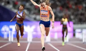 Femke Bol cruza la meta en una carrera de atletismo, con otras competidoras detrás.