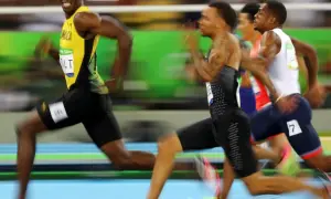 Usain Bolt, con su icónico uniforme amarillo, lidera la carrera de 100m, buscando batir su propio récord.