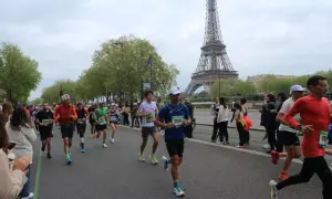 Corredores participan en el maratón de París, con la Torre Eiffel como telón de fondo.