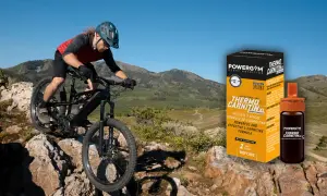 Ciclista de montaña desciende por terreno rocoso. A su lado, caja y vial de Powergym Thermo Carnitina XL, para saber como tomar l carnitina.
