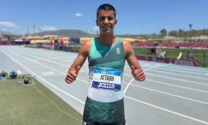 Mohamed Attaoui, atleta sonriente con dorsal, da pulgares arriba en la pista de atletismo.