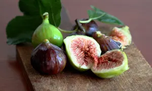 Frescos higos verdes y morados, algunos cortados, listos para comer.