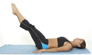 Mujer haciendo ejercicios para bajar barriga, elevando piernas en colchoneta azul.