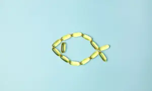 Cápsulas de aceite de pescado forman un pez, representando los omega 3 beneficios y contraindicaciones.