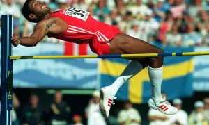 Atleta en pleno salto de altura, superando la barra en un intento por batir el récord mundo salto altura.