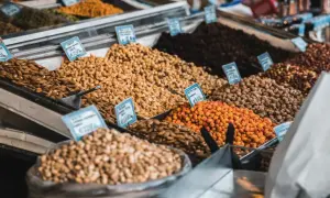 Montones de frutos secos en un mercado, incluyendo almendras que engordan.