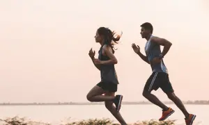 Pareja corriendo al amanecer. Para mantener la energía, es importante saber como tomar electrolitos.