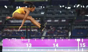 Ana Peleteiro en pleno salto de longitud, buscando su mejor marca. La atleta española vuela sobre la arena, superando los 14 metros.