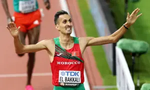 Soufiane El Bakkali, atleta marroquí, celebra su victoria en la pista, con los brazos en alto y una expresión de júbilo.
