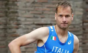 Alex Schwazer, atleta italiano, con la bandiera italiana sul petto.