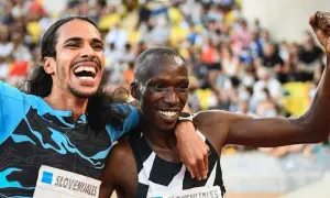 Dos atletas celebran un logro en España, quizás un nuevo récord España 1500. Uno levanta el puño, el otro sonríe con júbilo.