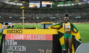Shericka Jackson, campeona y récord en 200m, celebra con la bandera de Jamaica y su medalla de oro.