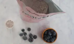 Bolsa de creatina, cucharada de polvo y arándanos. Consulta sobre creatina y embarazo.