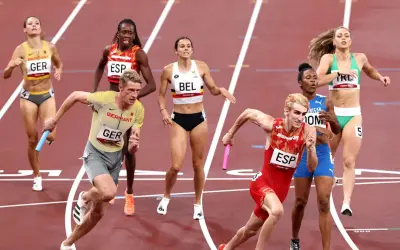 Atletas compiten en una carrera de relevos 4x400 mixto. El equipo de Alemania lidera, con España y Bélgica cerca.