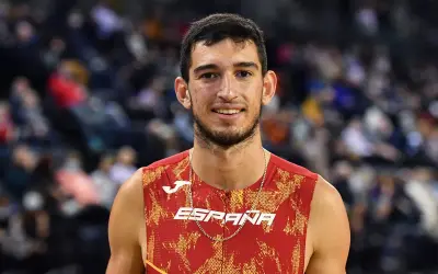 Atleta español sonríe, luciendo su uniforme de **llopis atletismo**.