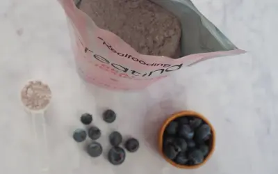 Bolsa de creatina, cucharada de polvo y arándanos. Consulta sobre creatina y embarazo.