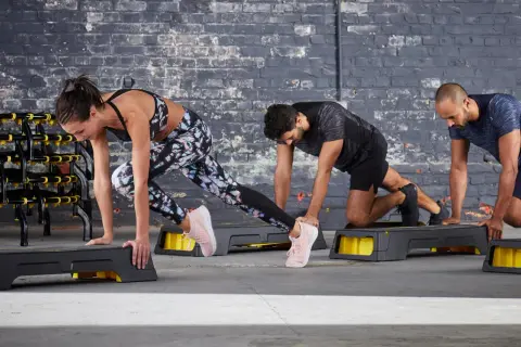 Tres personas hacen ejercicio en step. Queman que son las calorías con cada movimiento.