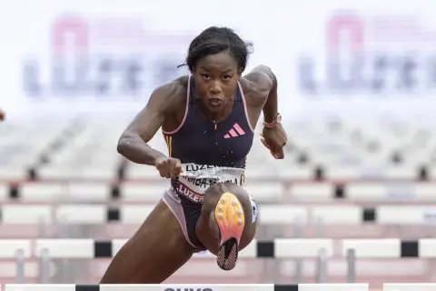 Atleta supera vallas en carrera de 110 metros.
