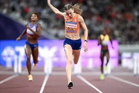 Femke Bol cruza la meta en una carrera de atletismo, con otras competidoras detrás.