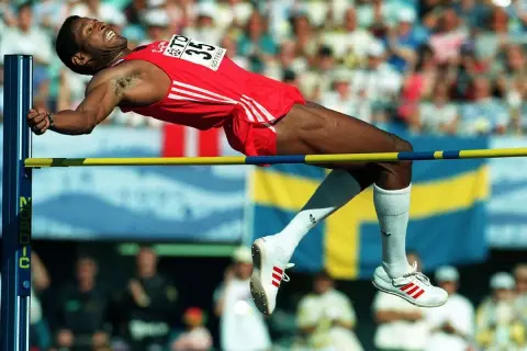 Atleta en pleno salto de altura, superando la barra en un intento por batir el récord mundo salto altura.