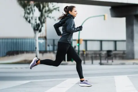 Mujer corriendo en la calle, demostrando una excelente técnica de carrera.