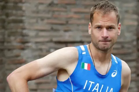 Alex Schwazer, atleta italiano, con la bandiera italiana sul petto.