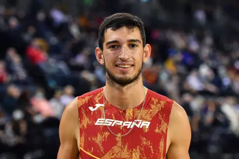 Atleta español sonríe, luciendo su uniforme de **llopis atletismo**.