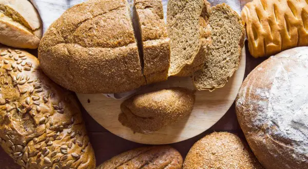 Variedad de panes, algunos cortados, otros enteros. ¡Cuidado! el pan engorda el abdomen si se abusa de él.