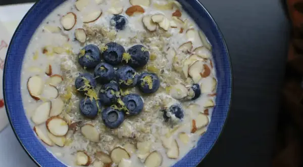Un tazón de avena con arándanos y almendras. La inulina para que sirve, como fibra prebiótica, mejora la digestión y la salud intestinal.