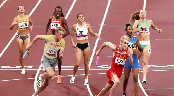 Atletas compiten en una carrera de relevos 4x400 mixto. El equipo de Alemania lidera, con España y Bélgica cerca.