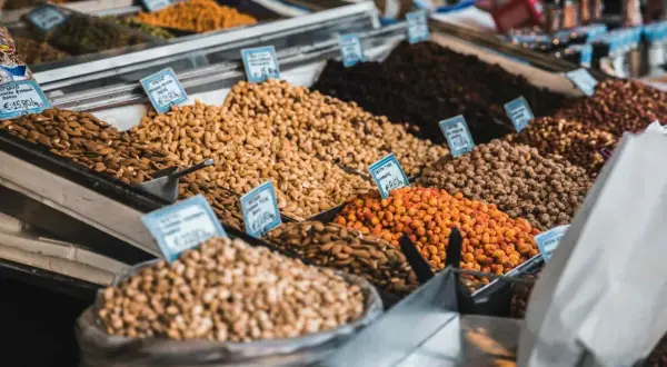 Montones de frutos secos en un mercado, incluyendo almendras que engordan.