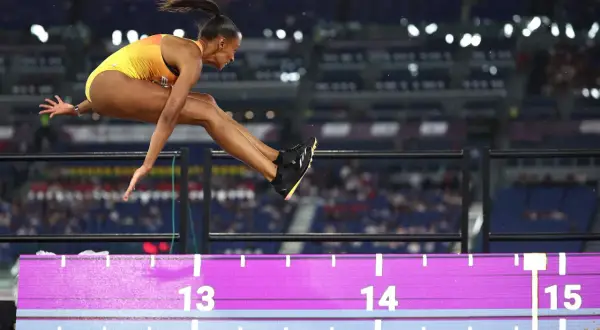 Ana Peleteiro en pleno salto de longitud, buscando su mejor marca. La atleta española vuela sobre la arena, superando los 14 metros.