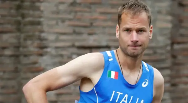 Alex Schwazer, atleta italiano, con la bandiera italiana sul petto.