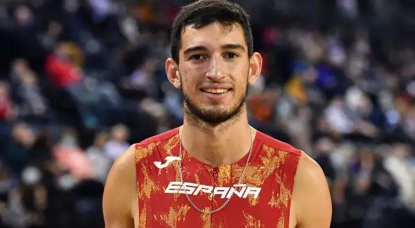 Atleta español sonríe, luciendo su uniforme de **llopis atletismo**.