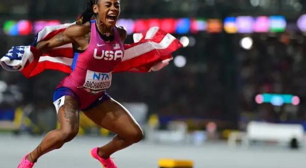 Sha'Carri Richardson, campeona 100 metros femeninos atletismo, celebra con la bandera de EE. UU. tras ganar.
