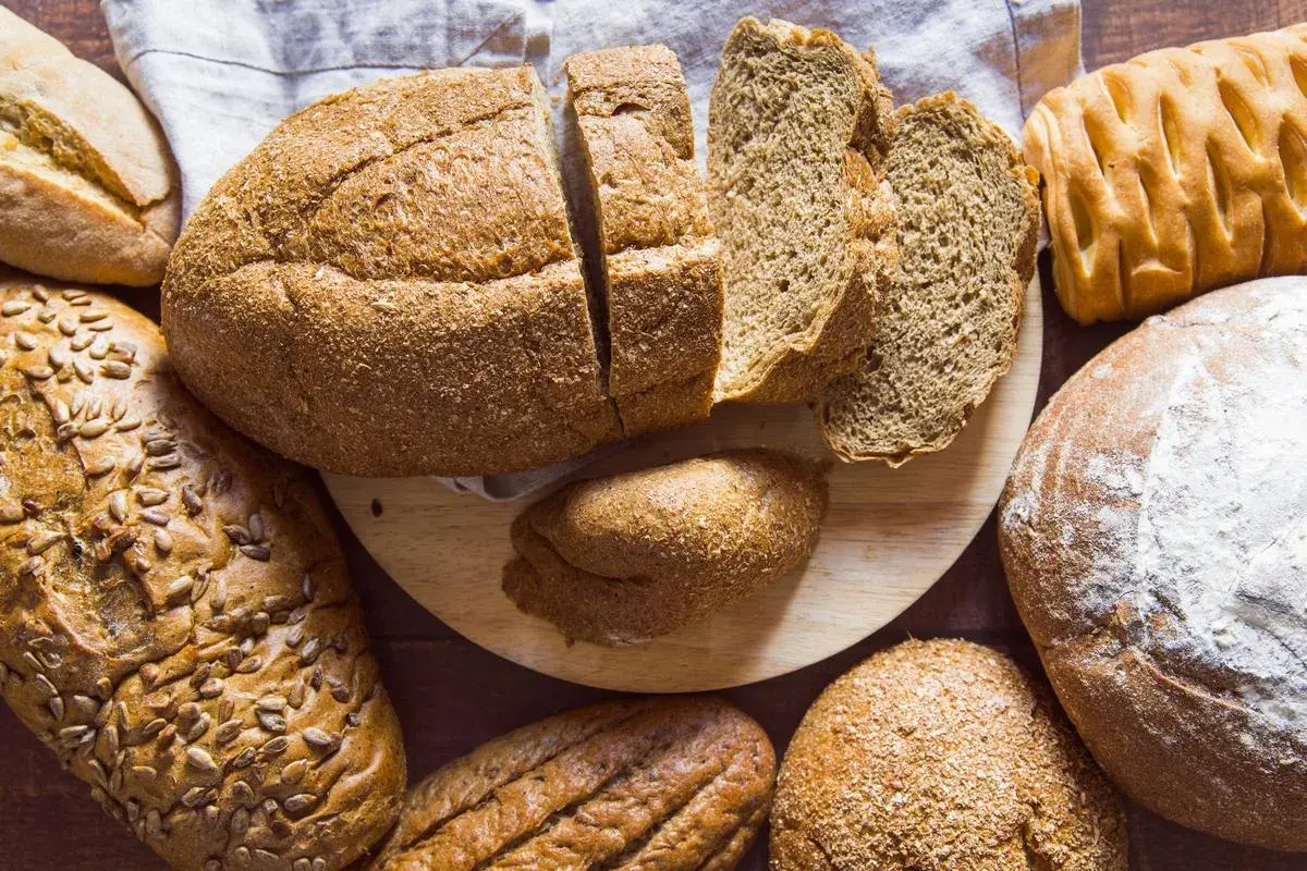 Variedad de panes, algunos cortados, otros enteros. ¡Cuidado! el pan engorda el abdomen si se abusa de él.