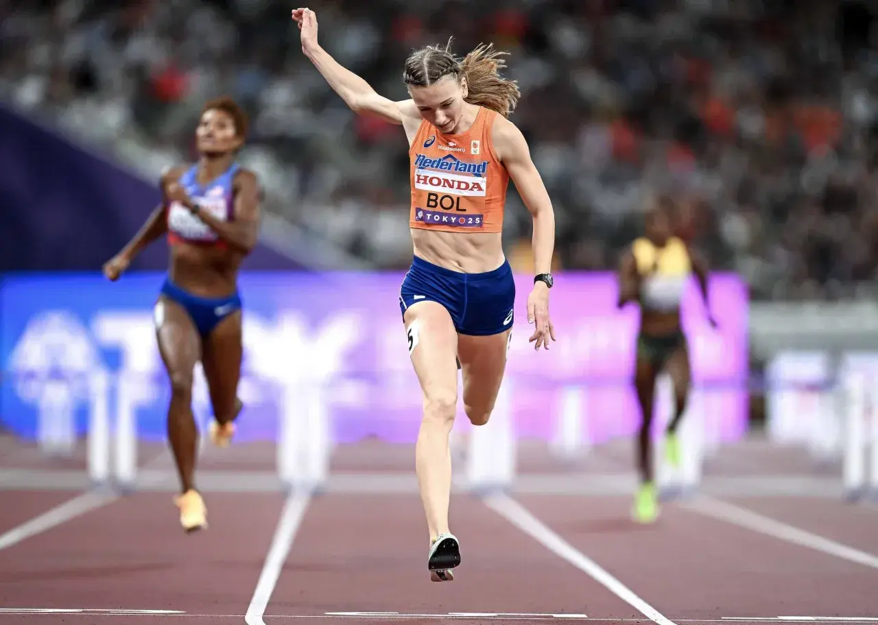 Femke Bol cruza la meta en una carrera de atletismo, con otras competidoras detrás.