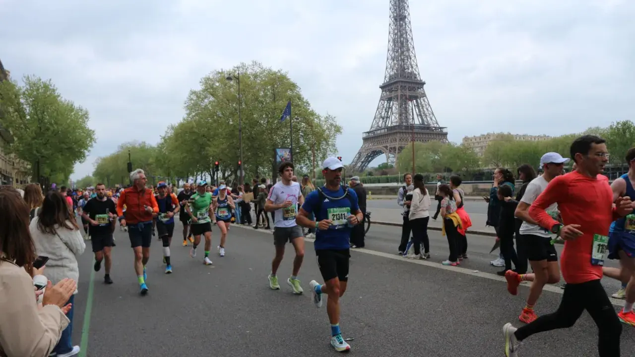 Corredores participan en el maratón de París, con la Torre Eiffel como telón de fondo.