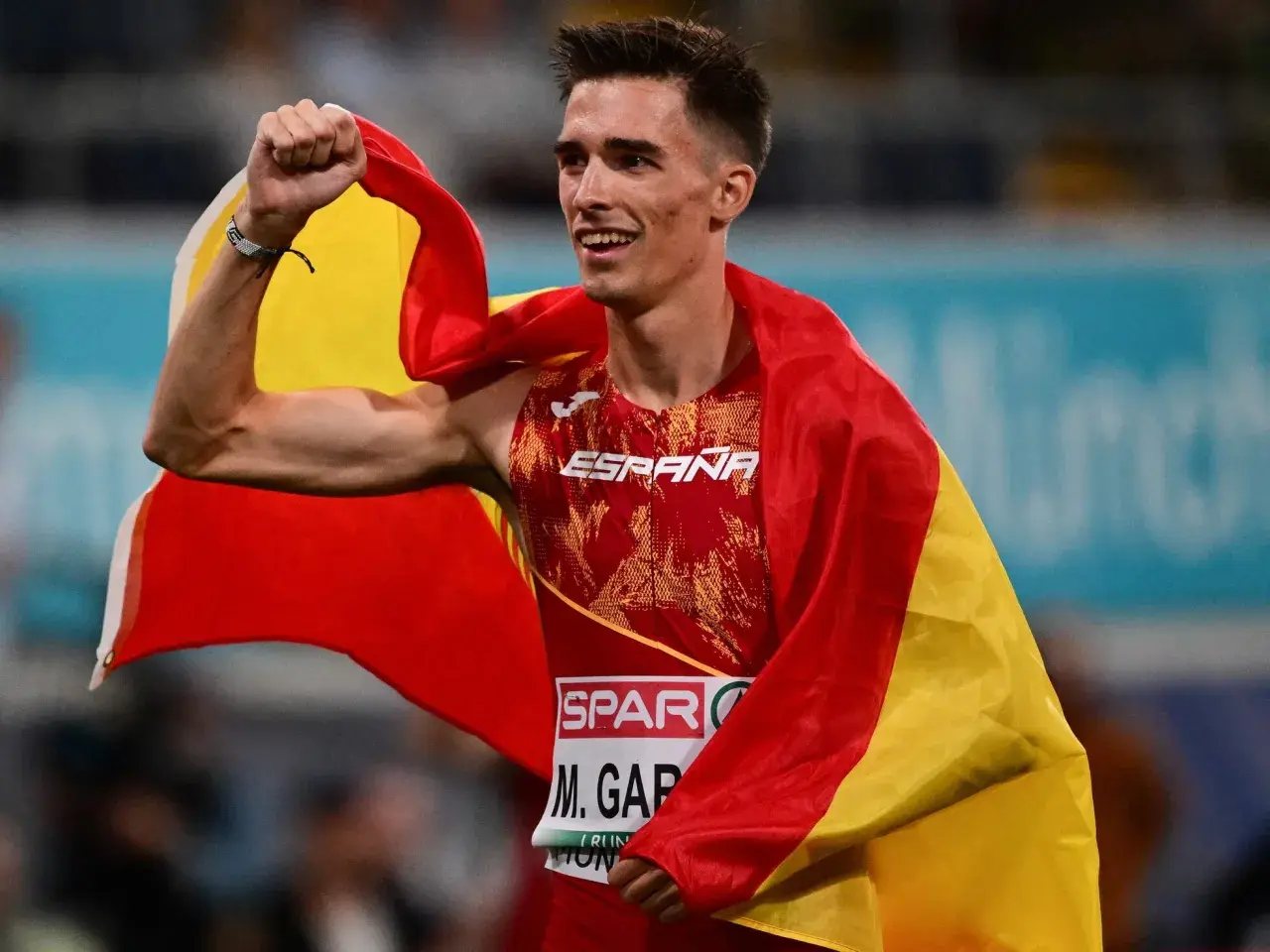 Mario García Romo celebra con la bandera de España, victorioso tras una carrera.