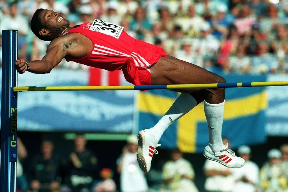 Atleta en pleno salto de altura, superando la barra en un intento por batir el récord mundo salto altura.