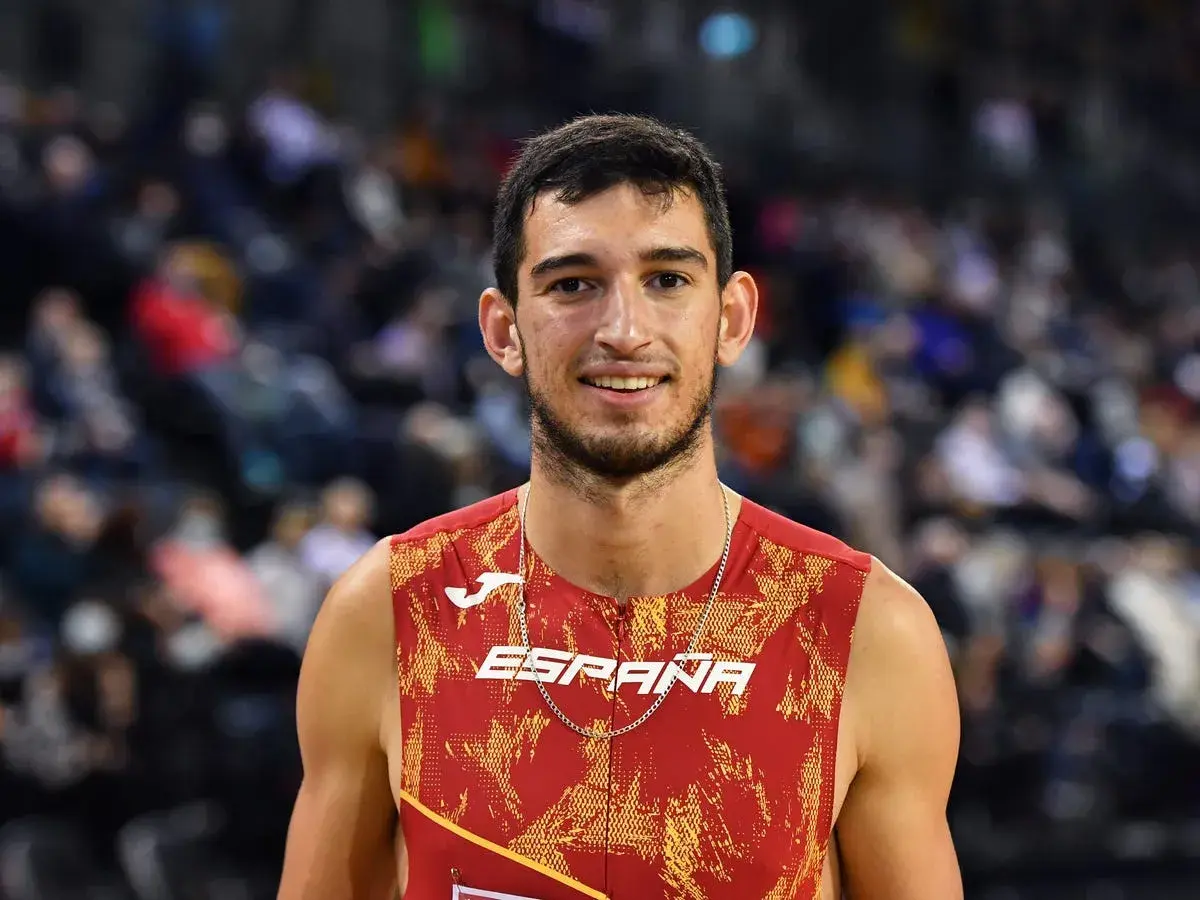 Atleta español sonríe, luciendo su uniforme de **llopis atletismo**.