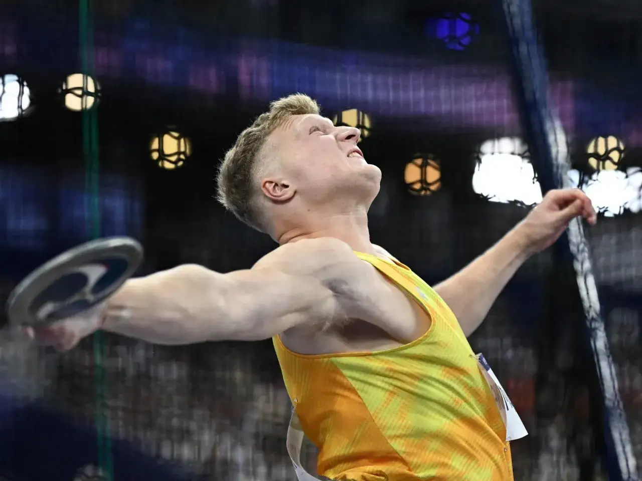 Mykolas Alekna, atleta lituano, lanza el disco con fuerza y concentración.