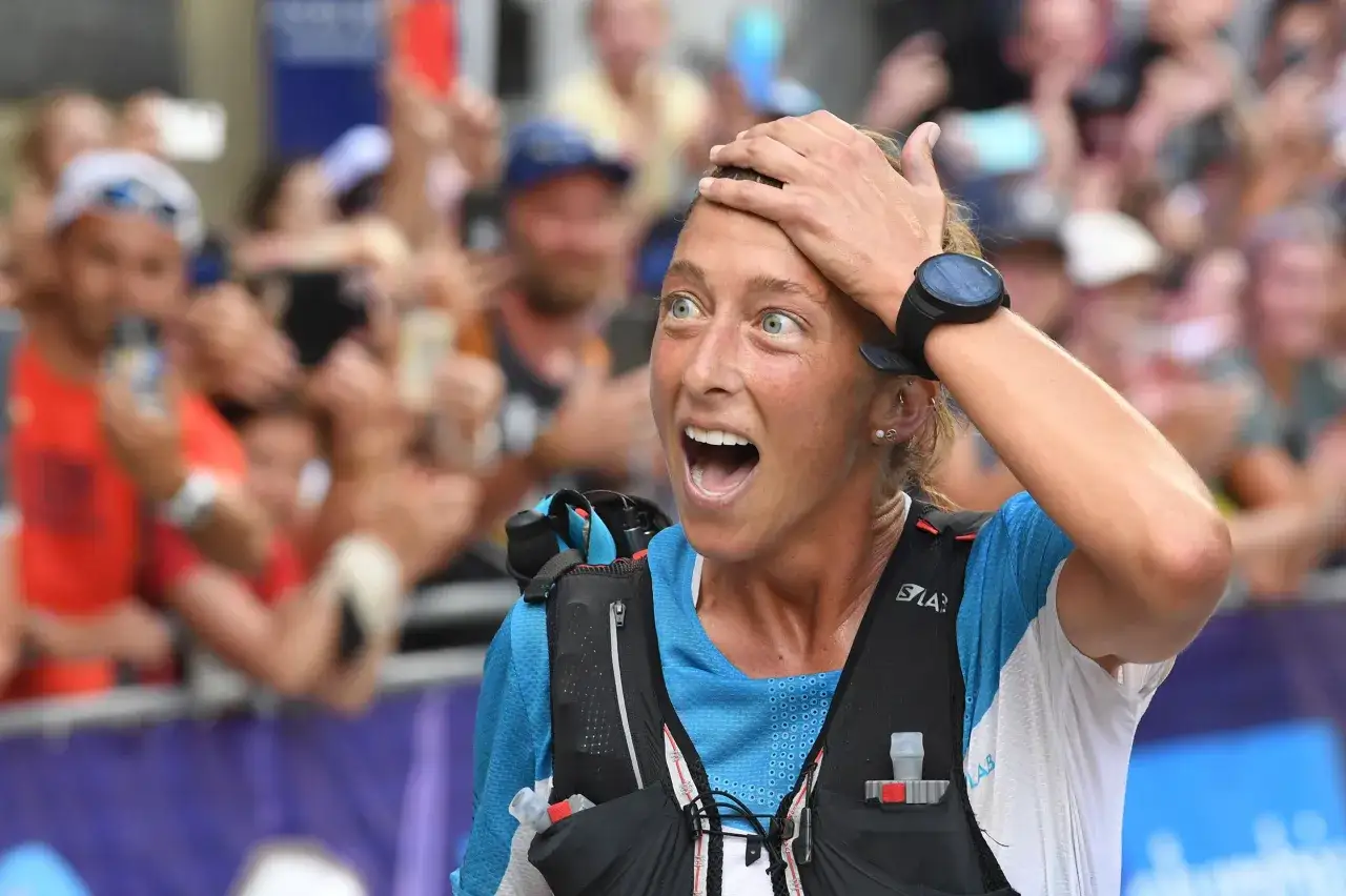Courtney Dauwalter, con la mano en la frente y una expresi&oacute;n de asombro, celebra un logro en una carrera.