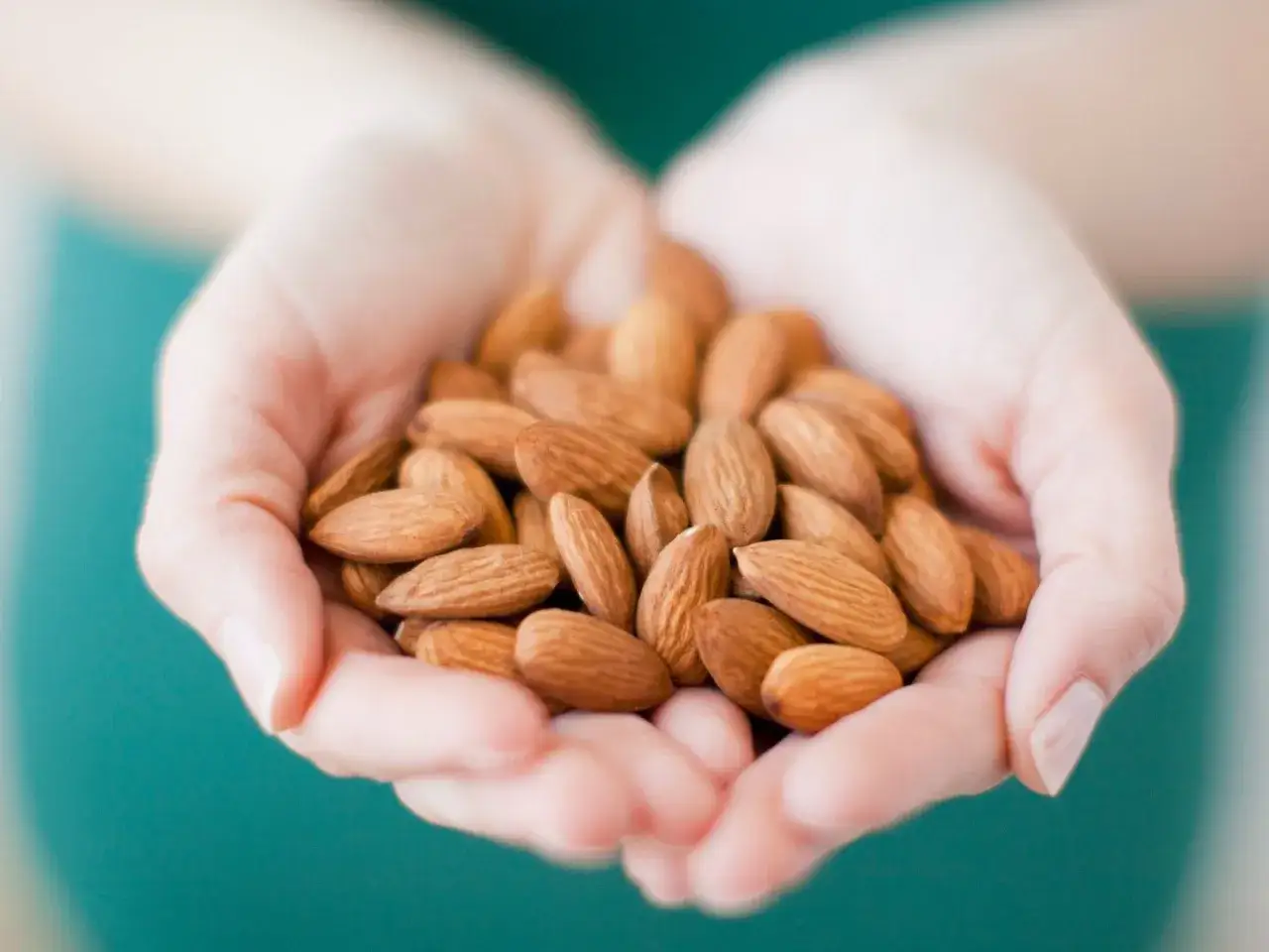 Manos sostienen un puñado de almendras. Estos frutos secos son perfectos para un snack saludable y, aunque algunos creen que engordan, son una fuente de nutrientes.