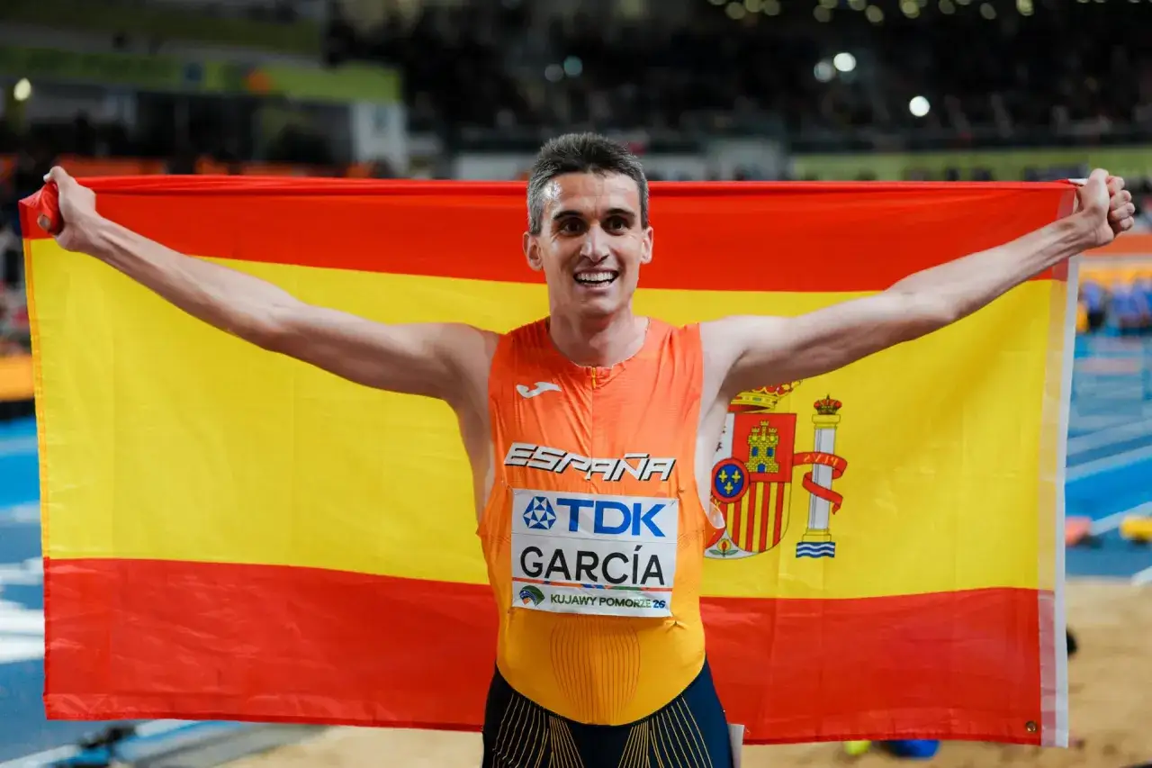 Atleta español celebra con la bandera de España. Un momento de orgullo, quizás un nuevo record España 1500.