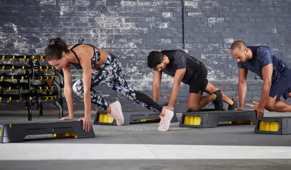 Tres personas hacen ejercicio en step. Queman que son las calorías con cada movimiento.