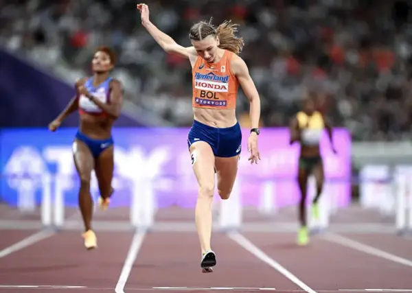 Femke Bol cruza la meta en una carrera de atletismo, con otras competidoras detrás.